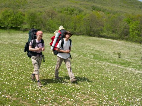 Couple of tourists are walking on the meadow