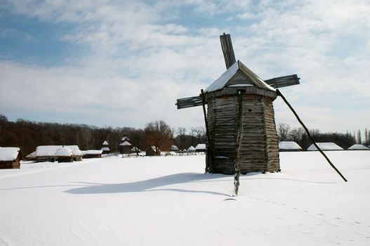 Windmill near village in the winter countryside scenic 