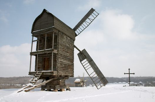 Old wooden windmiils on the snowy hill 