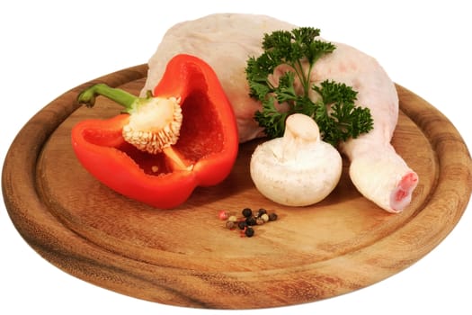 Raw chicken leg with vegetables on bright background