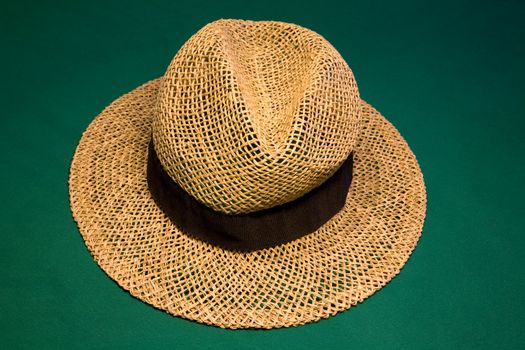 Straw hat on the green casino table
