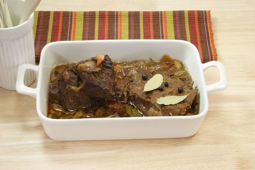 Cooked marinated beef meat in a bowl on bright background.