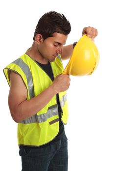 Builder construction worker putting on yellow protective hard hat.  He is also wearing a high visibility vest.  White background.