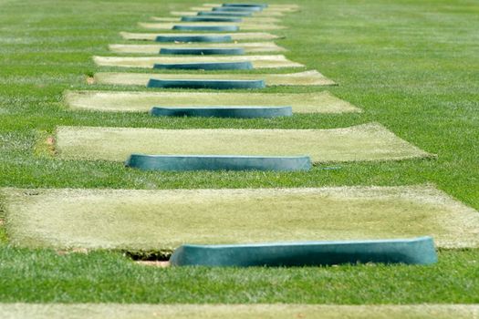 tee off at a driving range with green grass