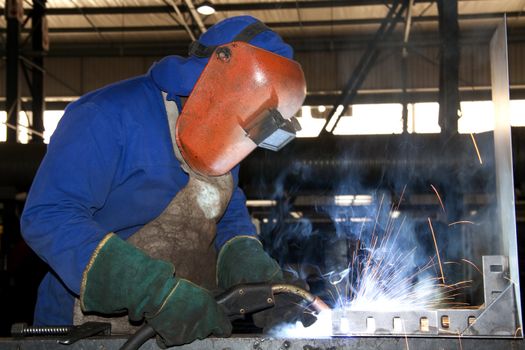 Factory Worker, wearing protective gear, Welding