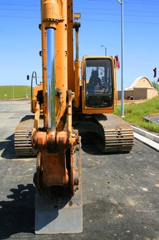 Yellow excavator close up on a construction sight.
