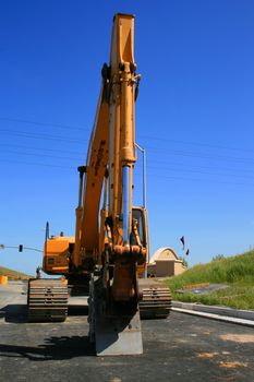 Yellow excavator close up on a construction sight.
