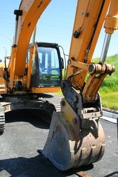 Yellow excavator close up on a construction sight.
