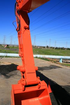 Orange excavator close up on a construction sight.
