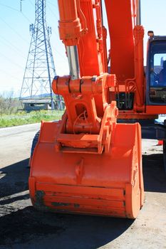 Orange excavator close up on a construction sight.
