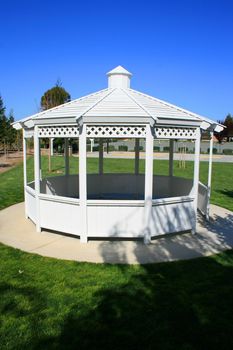 Close up of a white gazebo in a garden.
