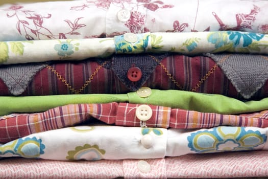 stack of colored shirt, front view, details of buttons