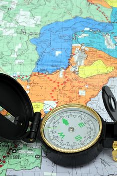 A black lensatic compass on hiking map