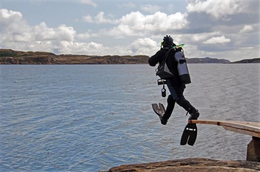 A scuba diver jumping from a diving board