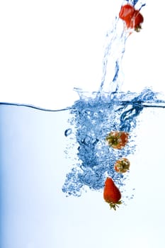 Strawberries splashing in water 