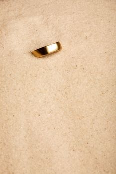 A wedding ring buried in the sand - lost