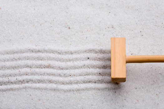 A small rake, creating a design in a zen garden