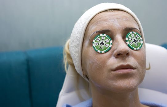 Poker chips lying on eyes like cucumbers in spa salon
