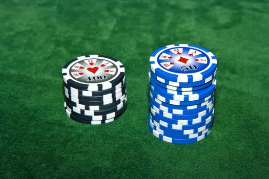 Poker table with 50 and 100 dollar chips on it