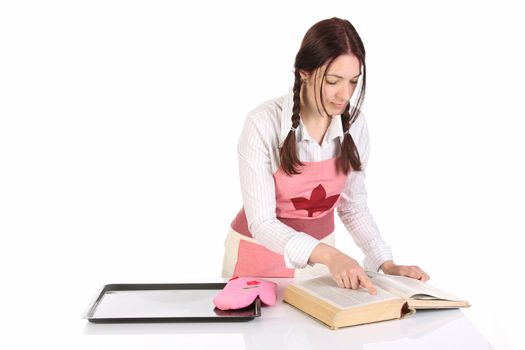 beautiful housewife preparing and reading with a book recipe