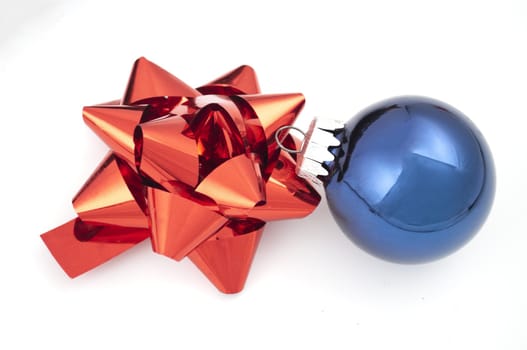 Red bow and blue christmas ball on white