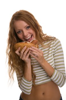 red-haired girl eating a hot dog on a light background