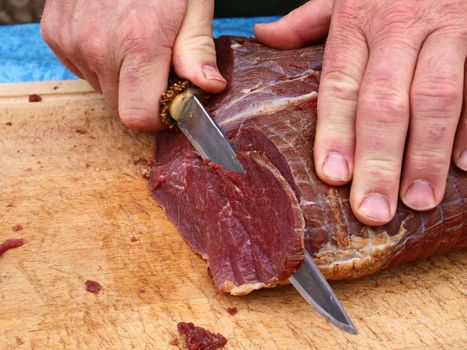 Cut smoked roasted meat beef by a professional chef butcher