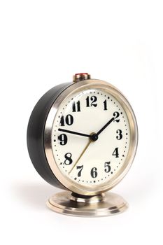 old alarm clock with gold trim on a white background