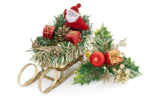 Santa Claus on a sleigh near an ornamental holly