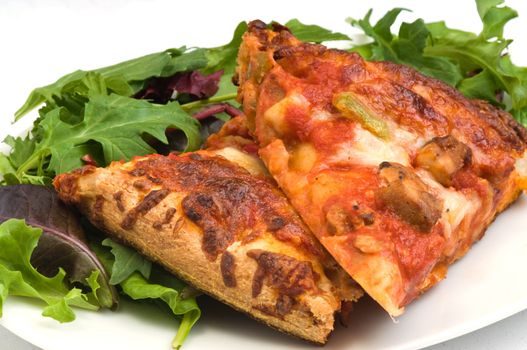 Slices of homemade pizza with a mixed salad.