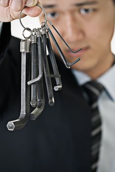 Businessman hang up tools on hand and watch.