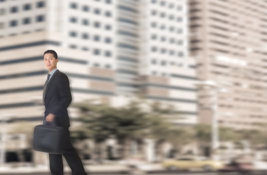 Young businessman walking in street of modern city.