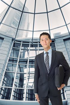 Young businessman of Asian stand inside modern building.