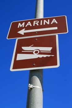 Marina direction street sign over blue sky.
