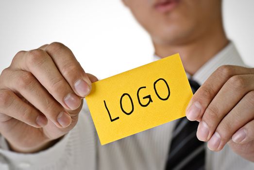 Logo words on yellow card hold by business man.