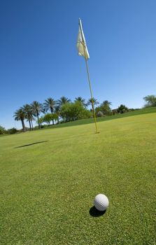 Image of a golf ball ongreen with flag