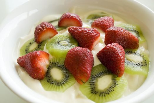large bowl of yoghurt with sliced fresh fruit on top