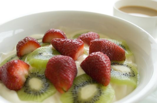 Fruit yoghurt and a cup of tea with a high key background