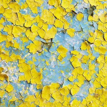 Yellow wall covered with scraps of an old paint