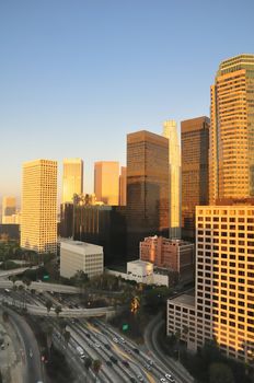 Los Angeles highrises over a busy freeway at sunset