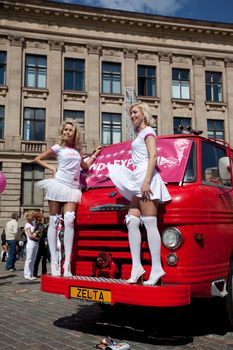 RIGA, LATVIA - MAY 29: Blonde girls posing at retro firefighter car during Go Blonde parade Organized by the Latvian Association of Blonds in May 29, 2010, Riga.