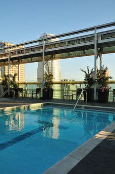 Clear blue pool overlooking skyscrapers near sunset