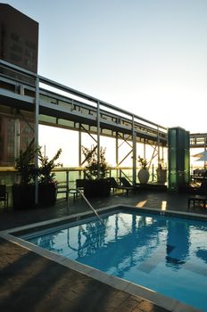 Swimming pool on city roof in last rays of sunset