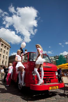 RIGA, LATVIA - MAY 29: Blonde girls posing at retro firefighter car during Go Blonde parade Organized by the Latvian Association of Blonds in May 29, 2010, Riga.
