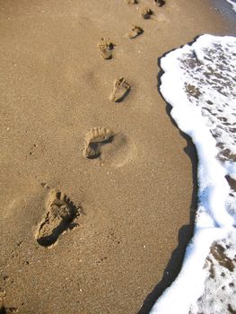 Human footprints leading along the sea