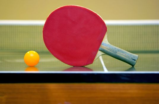 Ping pong ball and racket lying in the corner of the table