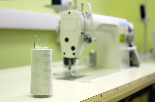 A sewing machine and thread spool on a table