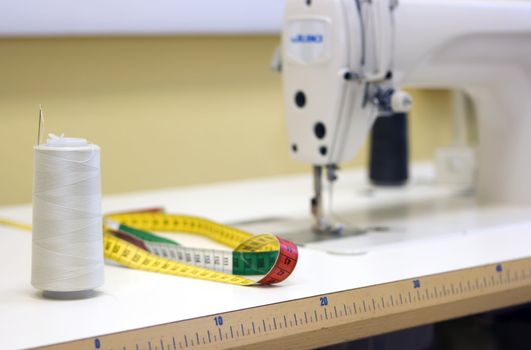 A sewing machine and thread spool on a table