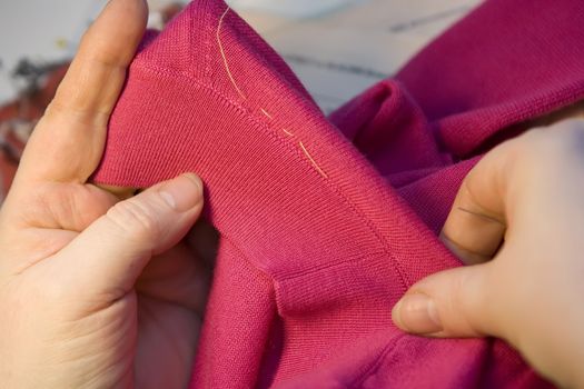 Tailor repairing clothes with needle and threads