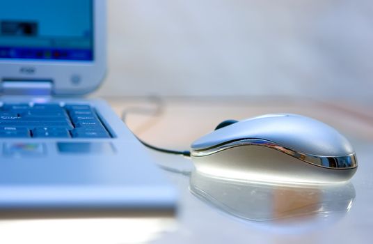 Computer mouse and notebook on dusty glass table